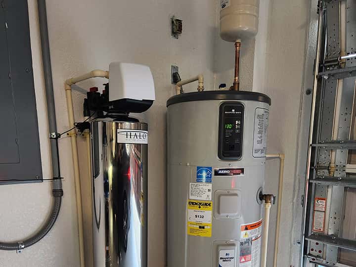 Water softener installed in garage next to water heater.